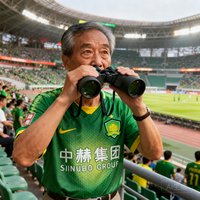 一位55岁左右的男性资深球迷在北京工体看球时拍摄的肖像照